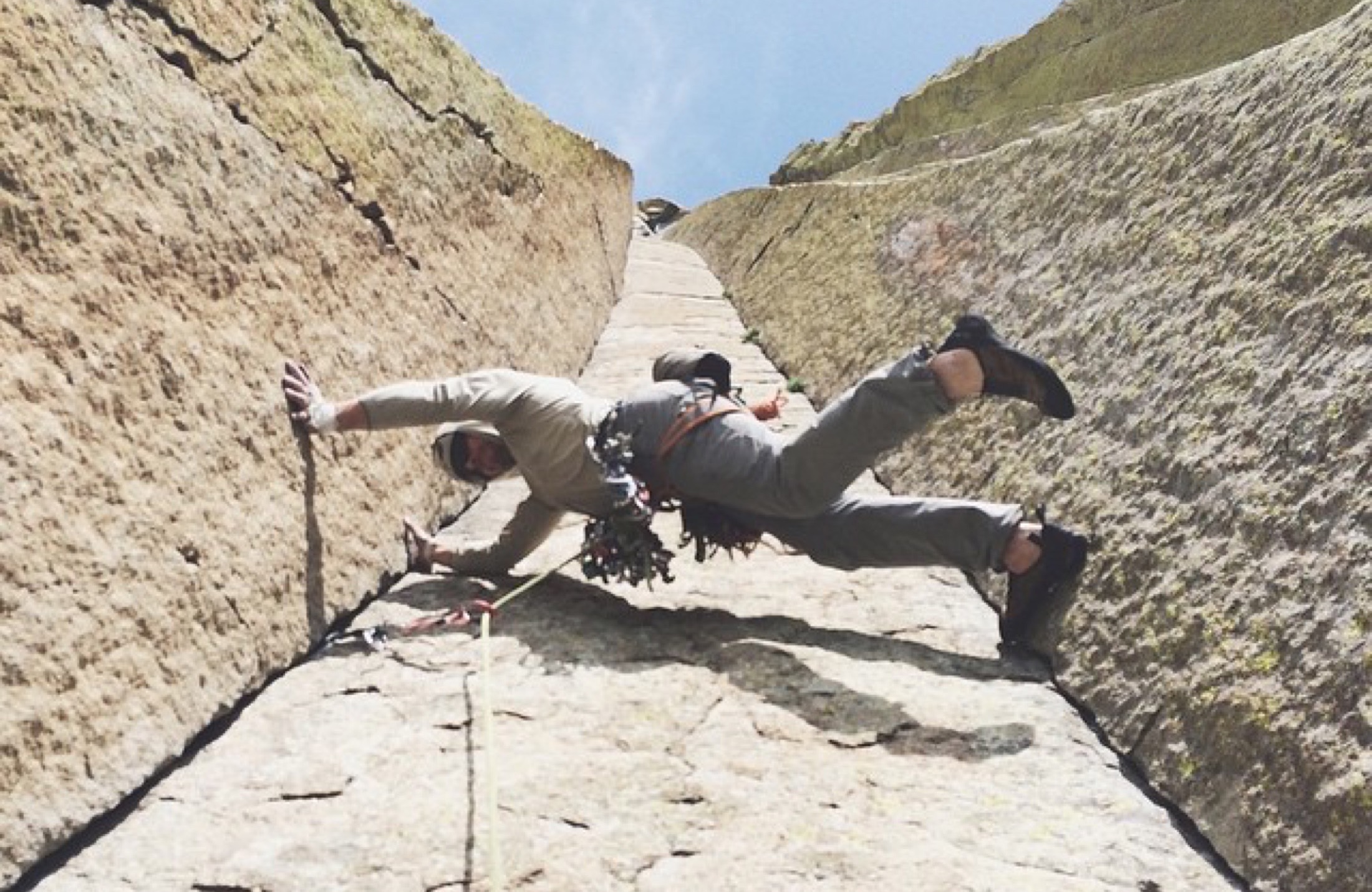 Climber making an unusual move at the start of a granite route